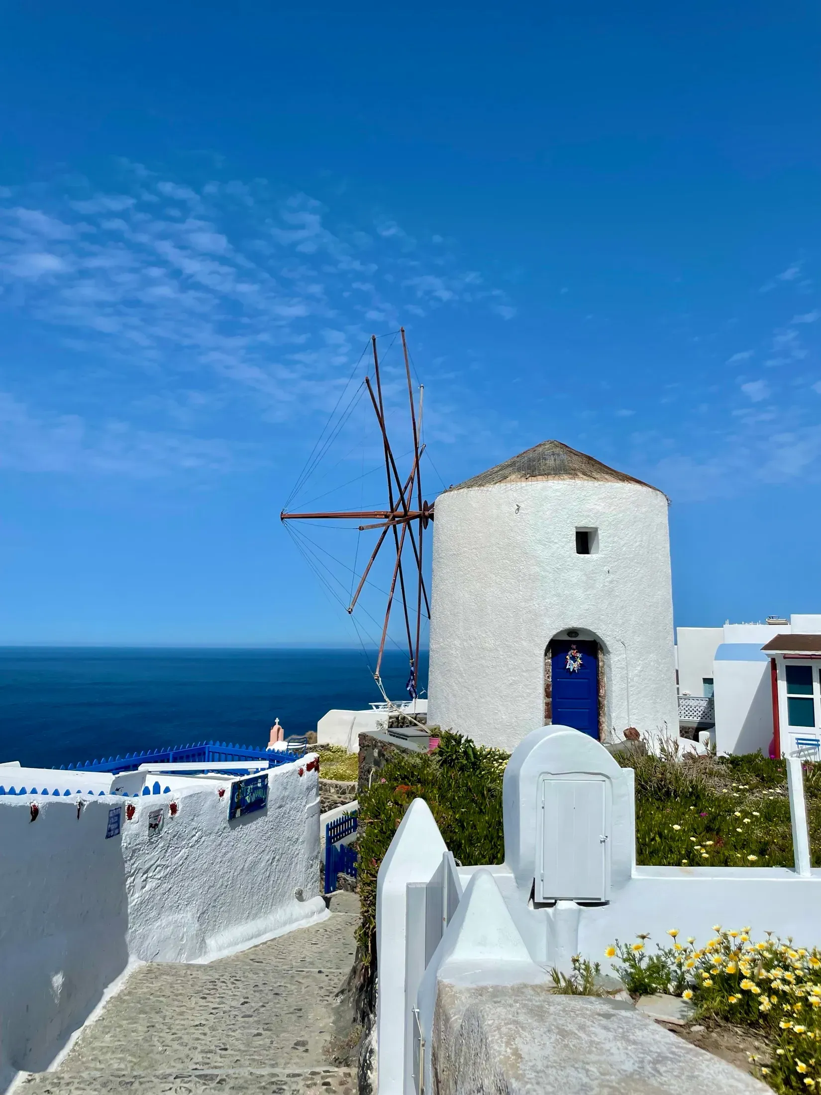 A whitewashed Cycladic windmill on a hill above the sea